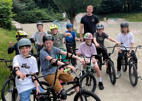 Eine Gruppe von Kids posiert auf BMX-Rädern für ein Gruppenfoto auf der Rollsportanlage Südstraße.